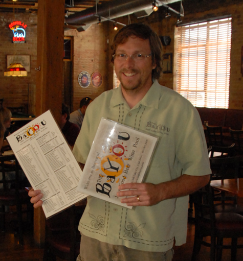 Owner Mark Alston proudly displays the Bayou's mammoth beer menu.