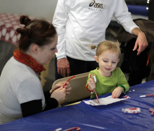 Isa Curnow enjoys the crafts station at the "Elf Village" with her family.
