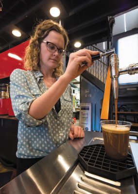 Jack Mormon Coffee Manager Sydney Groesbeck pours a cup of the coffee roaster’s nitro cold brew.