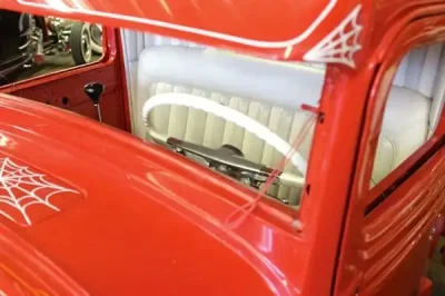 Red custom car with spiderweb detailing.