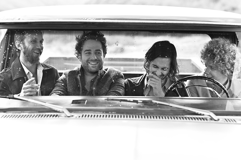 Dawes band members laugh together in a car