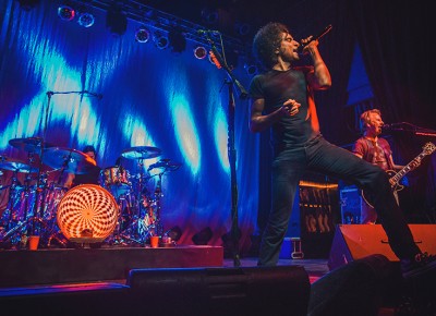 (L–R) Hidden behind the drums founding member Sean Kinney joins William DuVall and original guitarist Jerry Cantrell onstage as they return to Salt Lake City on Monday night. Photo: Talyn Sherer