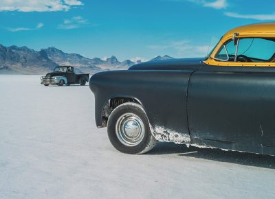 A 1953 Pontiac Chieftain sits on the flats near the pit area as a vintage truck drives past. There are many unique vehicles in addition to those racing, as they don’t need to be street legal to drive on the salt. Attendees use them to drive between the staging areas and pits, which are quite far apart.