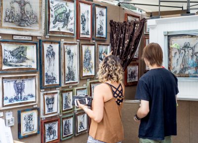 A couple looking at the unique ball point pen drawings of Tai Taeoalii. Photo: @nellis_j