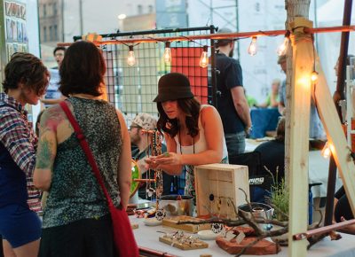 Rachel Ouzounian shows a piece of jewelry to customers at her Copper Elephant booth. Photo: @snowlenda