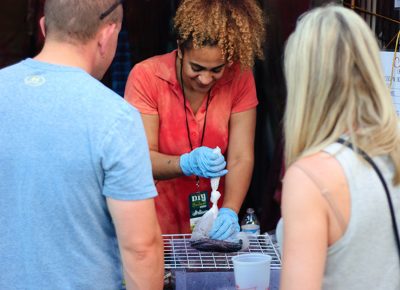 Candida Tandoh packages a T-shirt at her booth. At Candi's Tie Dye, people can learn how to dye clothing. Photo: @snowlenda