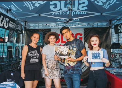 (L–R) SLUGgers Miriah Barkle and Aly Johnson were at the SLUG booth, where Jesus Rodriquez and Kat McComas came by to check out all the merch. Photo: @clancycoop