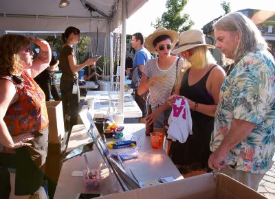 (L–R) Merch browsers Nancy Hoodes, Kira Hill-Filben and Mike Filben are all about Lake Street Dive’s socks, T-shirts and pins. Hoodes hopes to hear "Rabid Animal" tonight. Photo: John Barkiple