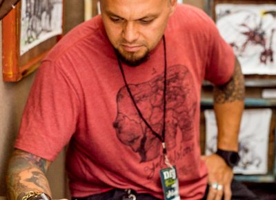 Tai Taeoalii works on a drawing in his booth. Photo: @nellis_j