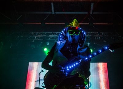 Through the darkness comes a blue-lit, laser-pointing, neon-glasses-wearing Steve Vai. Photo: Talyn Sherer