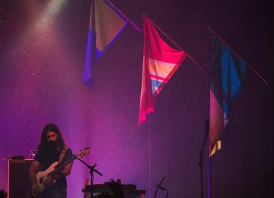 Payam Doostzadeh of Young the Giant plays out the bassy notes under the band’s signature flags from their latest album. Photo: Talyn Sherer.