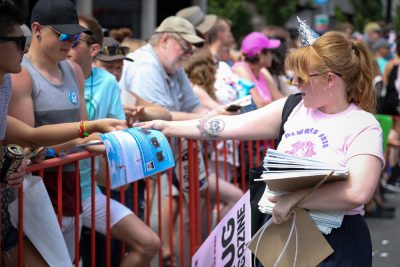 Vreni Romang passes out copies of SLUG Magazine as she marches in the Pride Parade. Photo: John Barkiple.