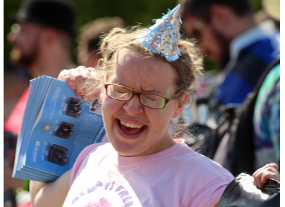 Sarah Donnelly get fired up as she prepares to carry the last banner in SLUG Magazine’s Pride processional. Photo: John Barkiple
