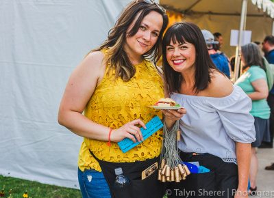 (L–R) Vine Lore reps Tatiana Subbotin and Whitney Norton passed out golden cork necklaces for those wishing to win a custom made firepit. Photo: Talyn Sherer