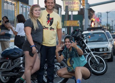 (L–R) Annelise Busch, Jeremy Wilkinson and Rileigh Aleshire pose in front of Busch’s and Wilkinson’s motorcycles. Busch appreciates the vintage and custom offerings from Gold Blood on 1526 South State. Photo: John Barkiple