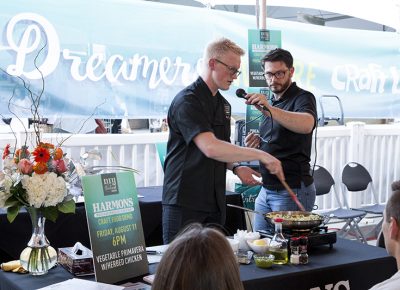 A Harmons Cooking School instructor shows the VIP audience how to make vegetable primavera with herbed chicken at their craft food demo. Photo: @jbunds