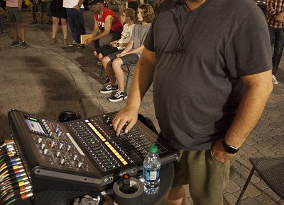 90.9FM KRCL Stage sound engineer John adjusts the levels for a performing band. Photo: @jbunds