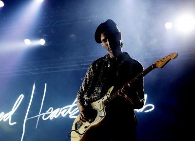 Guitarist for Foster the People killing it in front of the neon Sacred Hearts Club sign. Photo: Lmsorenson.net
