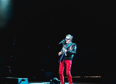 Muse frontman Matthew Bellamy singing alone, centerstage under a spotlight. Photo: Lmsorenson.net