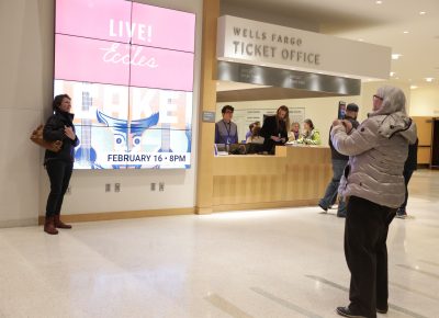 People take turns posing with the giant CAKE event screens in the lobby of the Eccles Theater. Photo: Lmsorenson.net