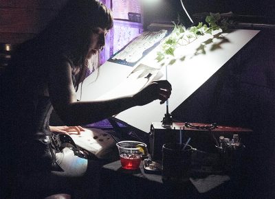 Mataya Maxfield working on a painting just left of the stage in Urban Lounge. Photo: Will Cannon
