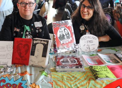 (L-R) Ricky Vigil and Donna Ramone head up the entrance table at Grid Zine Fest. Vigil’s Super Cool and Stuff goes back to 2011, and Ramone has contributed to Razorcake for more than eight years.