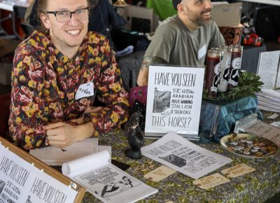 (L-R) Jordan Youngberg and Jordan Duke called their table Maurice von Margoza and Associates™. Youngberg is from Provo, and his horse-themed offerings drew a steady crowd.