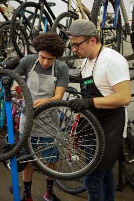 (L–R) Elijah Lowe and SLC Bicycle Collective Education Coordinator Kaden Coil-Pittman work on a mountain bike via the Collective’s revamped youth-education program. Photo: John Barkiple