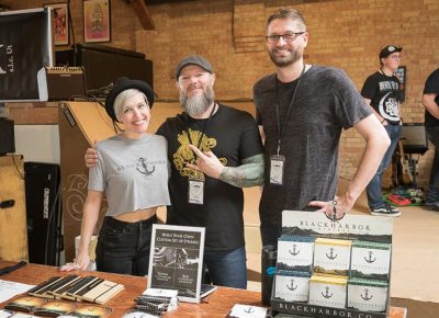 (L–R) Lizzy Tanner, Cory Jensen and Drew Ehrgott bring Black Harbor’s strings to SLAMM. Jensen, a serial entrepreneur, designs his strings for better action at the pickups, and his custom blend of alloys prevents the additional fret wear that could occur. Find out more @blackharborsound.