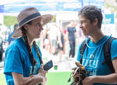 (L-R) Craft Lake City Executive Director Angela Brown and Production Volunteer Aimee Horman discuss installation options for the misters on the VIP Lounge at Craft Lake City’s Tenth Annual DIY Festival.