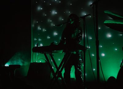 Side stage lighting and a starry green scrim surround Legrand as she performs.