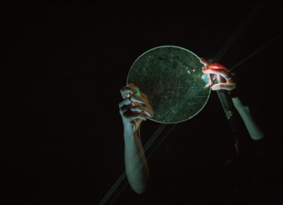 Karen using a glass plate to manipulate light beams on stage.