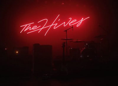 The Hives signage glowing behind the stage before the music begins. Photo: @Lmsorenson