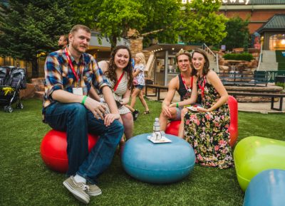 (L–R) Javin Hull, Alli Milne, Jarom West (designer for Salt Lake Magazine) and Madaline Slack take a break from the festivities to enjoy the relaxing lounge seats on the lawn.