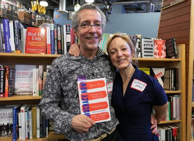 (L–R) Tony and Catherine Weller share their love for Amy Goodman while browsing their favorite section at Weller Book Works—the ISMs.