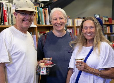 (L–R) Rep. Joel Briscoe, D-Salt Lake, Jane Colby and Monica Hilding stand between the economics and health aisles. Briscoe is looking for a used copy of Bruce Bartlett’s The Benefit and The Burden: Tax Reform-Why We Need It and What It Will Take.
