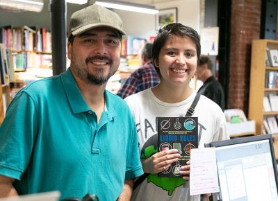 (L–R) Victor and Sophia Gener pick up a copy of Liquid Rules. Sohia is interested in science, and she starts her college career at the University of Utah in a week.