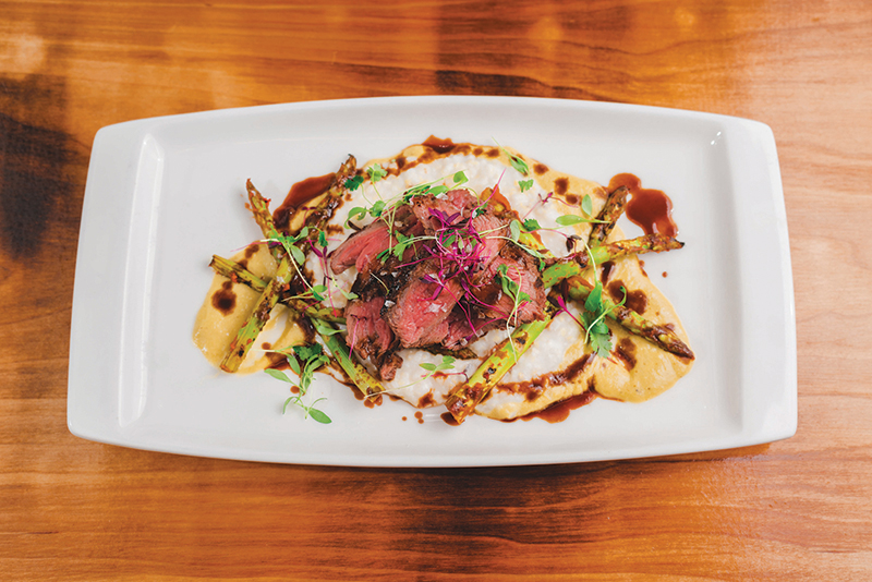 The Betel Smoked Beef rests on a bed of asparagus, reamy grits and Bordelaise.