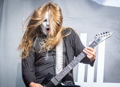 Hair flying and fingers flailing, Behemoth guitarist headbangs to their anthemic metal.