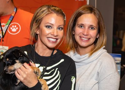 (L–R) Smok-A-Billy’s Stacey Burns and Missy Workman snuggle with a Chihuahua mix named Butterfingers at the Mark Miller Subaru Loves Pets booth. Is Butterfingers going home with Burns? “Not so far,” she said.