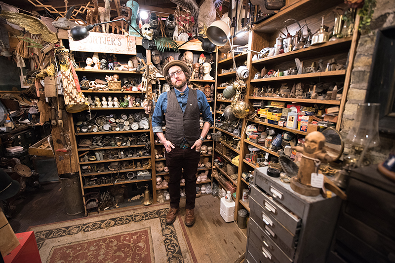 Jake Buntjer smiles from within his densely-stocked studio.