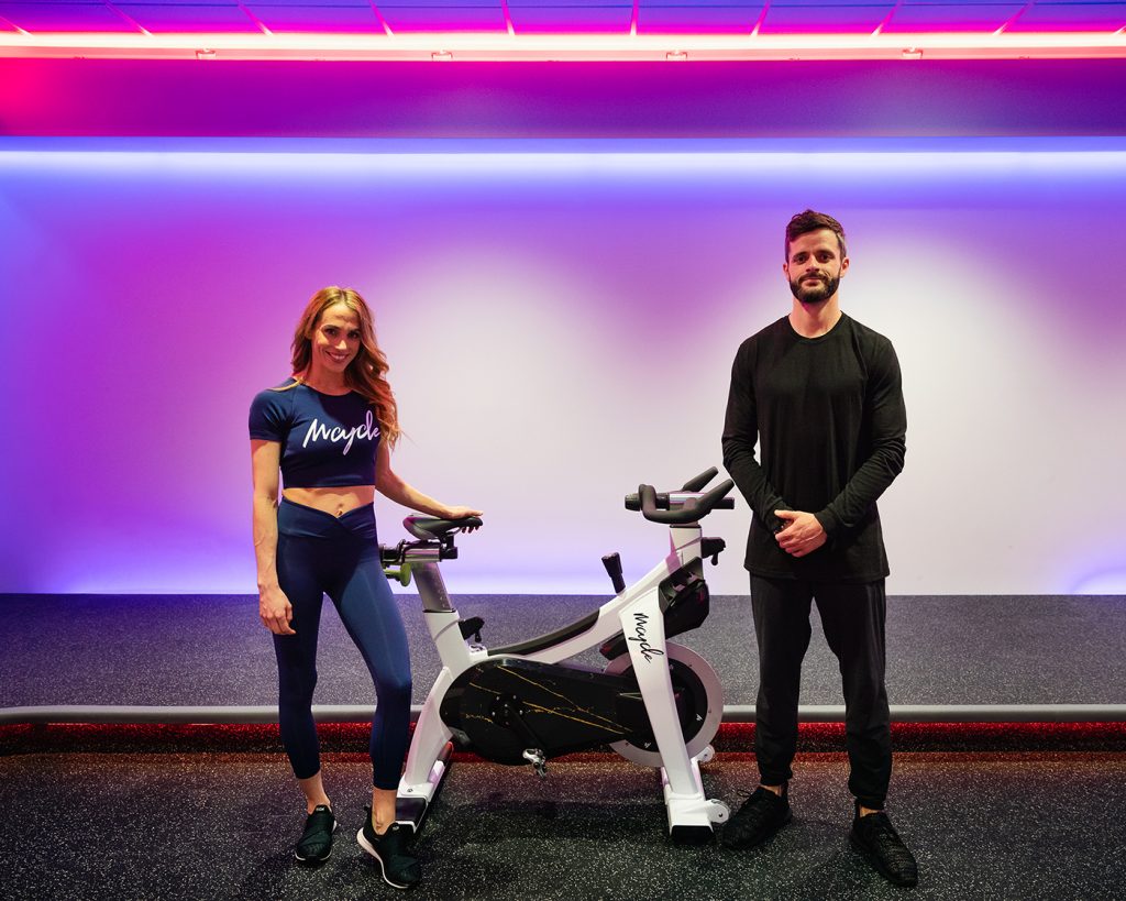 At Mcycle, (L–R) Megan and Richmond Tyrrell make it both fun and easy to give back to the community while pushing the wheel to some Missy Elliott during their 2000s-throwback rides.