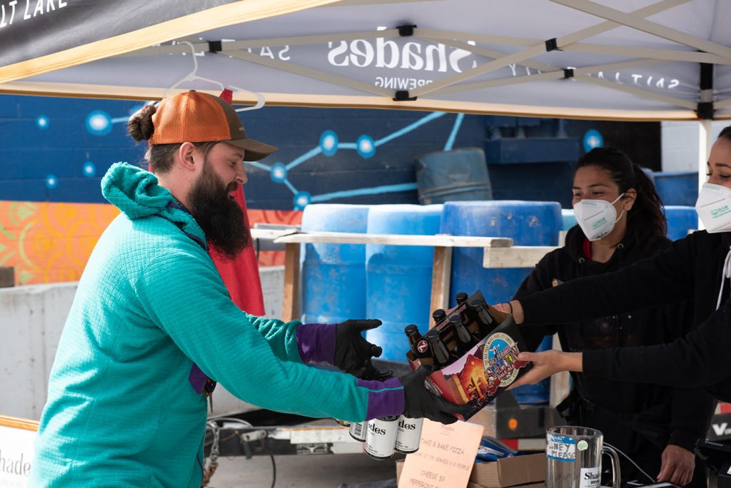 An excited beer drinker receives service from the Shades retail team. “Our customers' support has made it possible to keep all our employees employed,” says Co-Owner Alexandra Ortiz de Fargher.