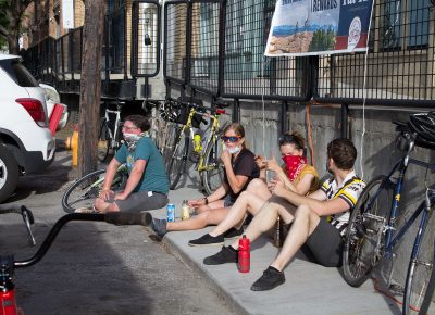 Some of the top SLUG Cat finishers engage in bike talk while perched on the ground.