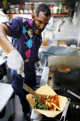 Abudujannah Soud plates a finished dish from his Kafé Mamai food truck.