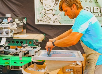 A local artisan makes some custom screen printing on site for our CLC guests.