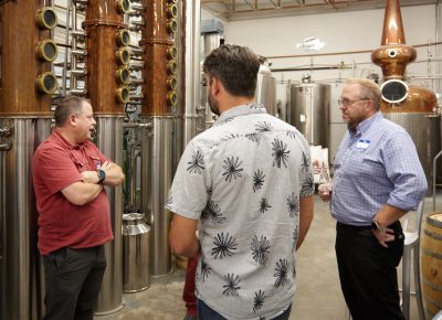 Distillery Owner James Fowler talking business with patrons, including Clinton Fowler of Pago.