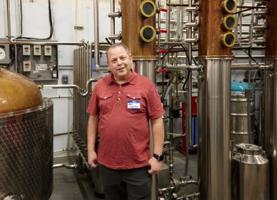 Owner James Fowler posing in front of some of the distillery equipment.