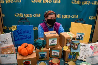 Ari Green runs the Craft Lake City merch booth at Holiday Market 2021.