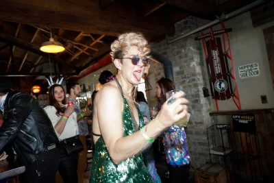 Person wearing green dress sticking their tongue out while dancing.